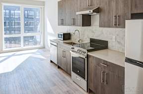 A kitchen with a stove top oven and a microwave at The Anthem at Square 10 Apartments, New Haven, Connecticut