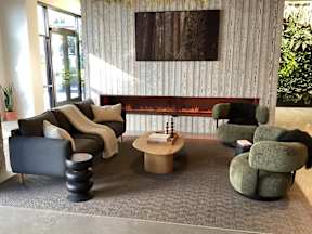 A living room with a grey carpet and a wooden wall at The Anthem at Square 10 Apartments, New Haven, CT