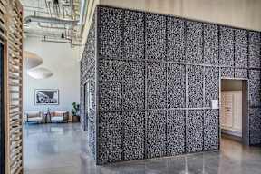 A room with a black and white patterned wall and a wooden staircase at The Anthem at Square 10 Apartments, New Haven, Connecticut
