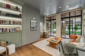 A living room with a couch, a chair, a coffee table, and a bookshelf.