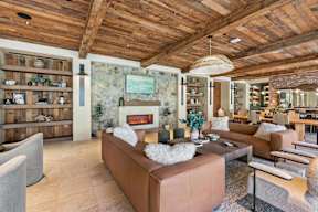 A living room with a brown couch and a wooden ceiling.
