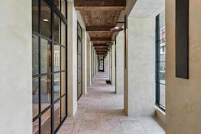 A long corridor with a wooden ceiling and tiled floor.