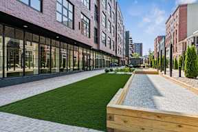 A long, narrow courtyard with a grassy area and a gravel area in the middle.