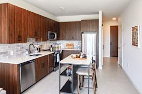 A kitchen with wooden cabinets and a white counter top.