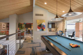 a pool table in a clubhouse at the district flats apartments in lenexa, ks