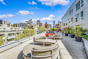 A rooftop patio with chairs and a table.