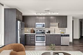 A modern kitchen with a refrigerator, oven, and microwave.