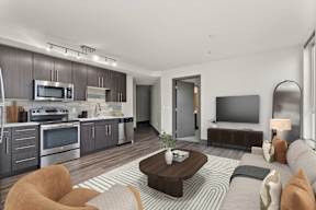 A modern living room with a kitchen area in the background.