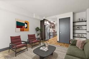 A living room with a green couch, a coffee table, and a painting on the wall.