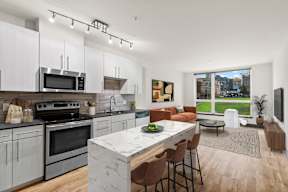 A modern kitchen with a large island and a view of the city.