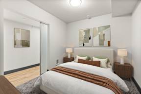 A bedroom with a large bed and two lamps.