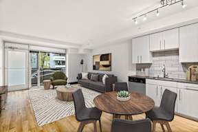 A modern kitchen and living room with a dining table and chairs.