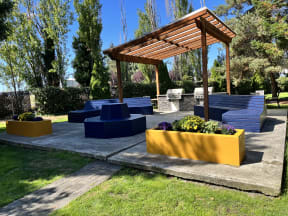 a patio with blue and yellow benches and a wooden pergola