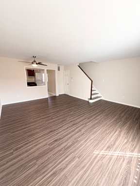 A room with a wooden floor and a staircase.