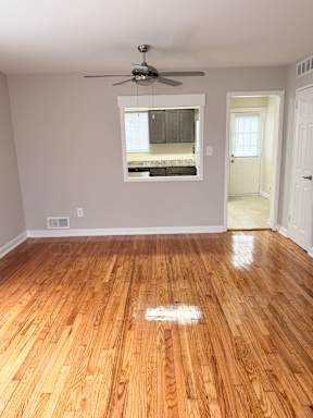 A room with a ceiling fan and a window.