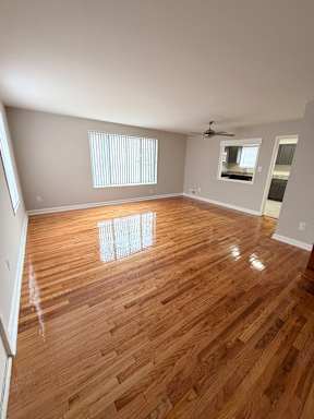 A room with wooden flooring and a ceiling fan.
