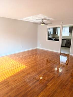 A room with wooden flooring and a ceiling fan.