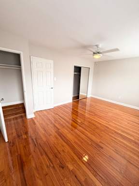 A room with a wooden floor and a ceiling fan.
