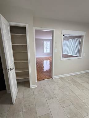 A room with a white door and a window with blinds.