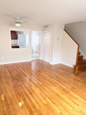 A room with wooden flooring and a staircase.