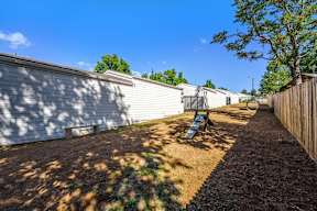 A backyard with a wooden fence and a playground.