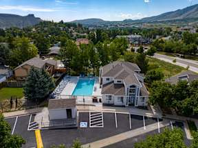 A bird's eye view of a residential area with a swimming pool and a parking lot.