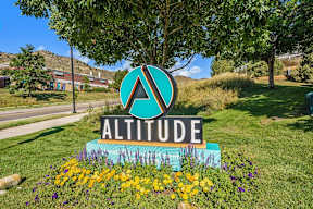 A sign that says Altitude in front of a building.