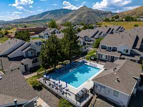 A swimming pool surrounded by houses with a mountain in the background.