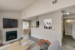 an open living room with a fireplace and a dining room and kitchen