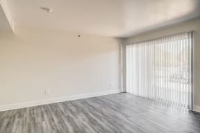 a bedroom with a large window and hardwood floors