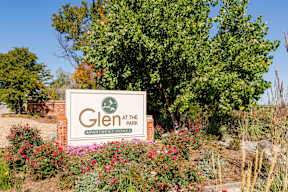 a sign for glen at the park in front of a tree