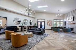 a lobby with couches and chairs and a bar with mirrors