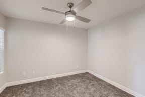 a bedroom with a ceiling fan and carpet