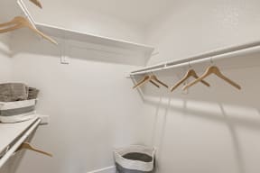 a walk in closet with a hanger and a basket
