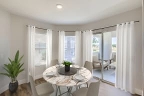a dining area with a round table and chairs and a sliding glass door leading to a patio