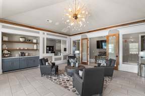 A modern living room with a grey sofa set and a chandelier.  at Mode at Melbourne Apartments, Melbourne, Florida