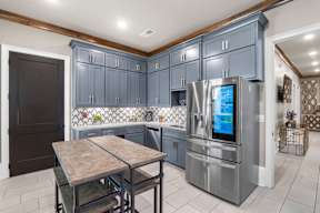 A kitchen with a table and chairs in front of a refrigerator.  at Mode at Melbourne Apartments, Melbourne, Florida