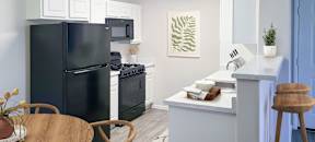 a kitchen with a black refrigerator freezer next to a stove top oven at Silver Creek Apartments, Las Vegas, Nevada
