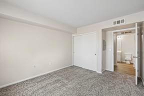 A room with a carpeted floor and a white door.