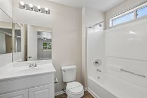 A white bathroom with a toilet, sink, and bathtub.
