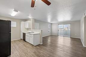 A kitchen with white cabinets and a black refrigerator.