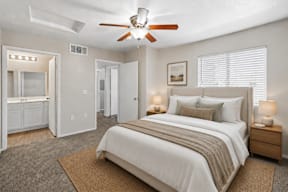 A bedroom with a large bed and a ceiling fan.