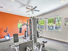 the gym has plenty of exercise equipment and a large window at Silver Creek Apartments, Las Vegas, NV, 89122