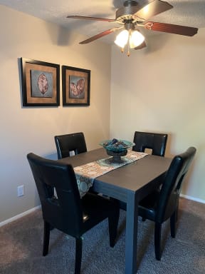 a dining room with a table and chairs and a ceiling fan