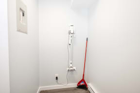 a white room with a red broom and a vacuum cleaner