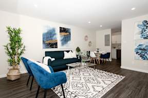 A living room with a blue chair and a white couch.
