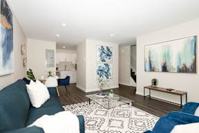 A living room with a blue couch and a white pillow.