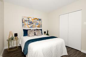A bedroom with a large bed and a painting on the wall.