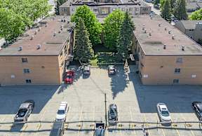 A parking lot with cars and a red car in the middle.