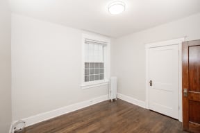 a bedroom with white walls and wood floors at 883 Grosvenor Avenue Winnipeg
